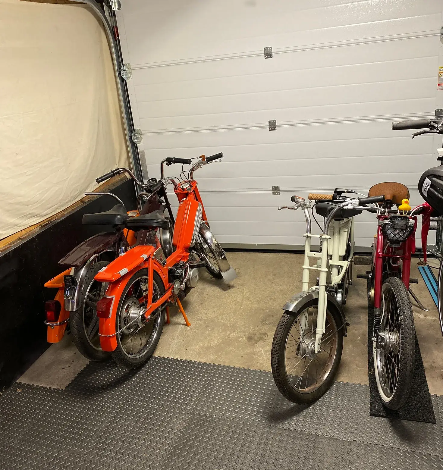 Des mobylettes à l'abri dans le garage de l'atelier